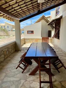 a wooden table and chairs on a patio at CASA BEIRA MAR NA BARRA DE SÃO MIGUEL in Barra de São Miguel