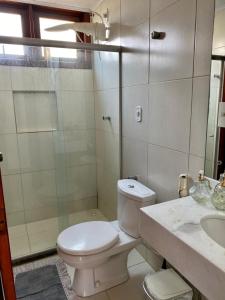 a bathroom with a toilet and a shower and a sink at CASA BEIRA MAR NA BARRA DE SÃO MIGUEL in Barra de São Miguel