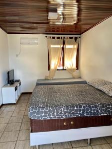 a bedroom with a bed and a window at CASA BEIRA MAR NA BARRA DE SÃO MIGUEL in Barra de São Miguel