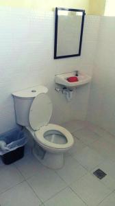 a bathroom with a white toilet and a sink at JR Pension House in Baybay