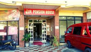 JR Pension House في Baybay: سيارة فان حمراء متوقفة أمام منزل بيتزا