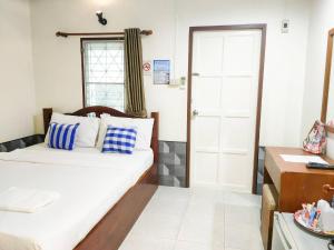 a small room with a bed and a window at Samet Bellhouse in Ko Samed