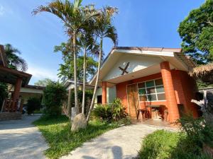 a house with palm trees in front of it at Bell House Resort in Ko Samed