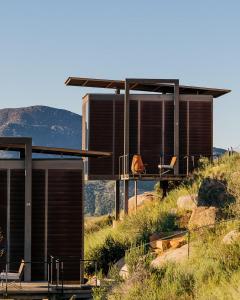a house on the side of a hill with chairs at Encuentro Guadalupe in Valle de Guadalupe