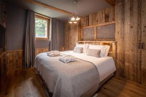 Schlafzimmer mit einem großen Bett und Holzwänden in der Unterkunft Madame Vacances Chalet Inuit in Val dʼIsère