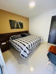 um quarto com uma cama com um cobertor preto e branco em Suites Santiago em Santiago