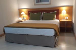 een slaapkamer met een groot bed met 2 nachtkastjes bij Flat com Sacada - Região Ibirapuera próximo vários Hospitais e UNIFESP in Sao Paulo