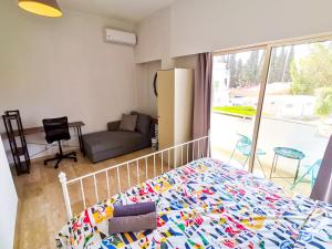 ein Schlafzimmer mit einem Bett, einem Sofa und einem Fenster in der Unterkunft Central Square Nomadic Rooms in Larnaka