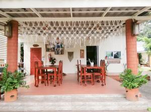 a patio with wooden tables and chairs on it at Bell House Resort in Ko Samed