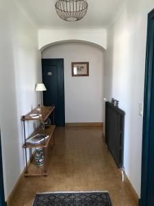 korytarz z niebieskimi drzwiami i stołem w obiekcie Chambre d'hôtes à la campagne w mieście Coings
