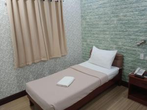 een kleine slaapkamer met een bed met een laptop erop bij AB Star Suites in General Santos