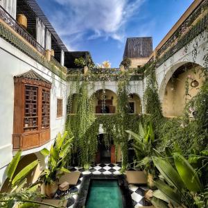 un edificio cubierto de hiedra con piscina en Sakkan, en Marrakech