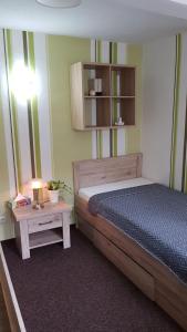 ein Schlafzimmer mit einem Bett und einem Tisch mit einer Lampe in der Unterkunft Ferienwohnung Froeschlein 3 in Ilmenau