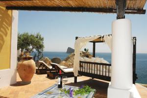 d'une terrasse avec une table et une vue sur l'océan. dans l'établissement Villa Rocce Rosse, à Panarea
