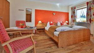 ein Schlafzimmer mit einem großen Bett, einem Tisch und einem Stuhl in der Unterkunft Gästehaus Heißenlehen in Ramsau bei Berchtesgaden