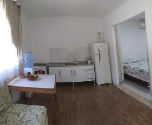 eine Küche mit einem Kühlschrank und einem Tisch darin in der Unterkunft RECANTO DE ZEZE - casa 2 in Ilhéus