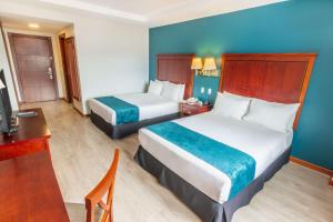 Habitación de hotel con 2 camas y escritorio en Sonesta Hotel Loja, en Loja