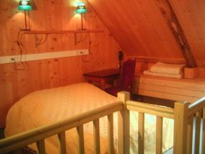 Quemper-GuézennecにあるLes Chambres d'hôtes d'Adèleの木造キャビン内のベッド1台が備わるベッドルーム1室を利用します。