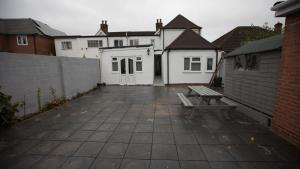 a patio with a bench in front of some buildings at Comfortable stay in Shirley, Solihull - Room-2 in Solihull