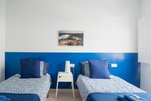 two beds in a room with blue walls at Blancazul Harbour View in Playa Blanca