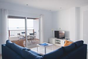 a living room with a blue couch and a television at Blancazul Harbour View in Playa Blanca