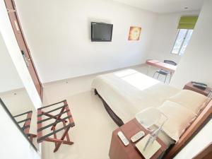 a hospital room with a bed and a tv at Atlantic Garden Hotel in Barranquilla