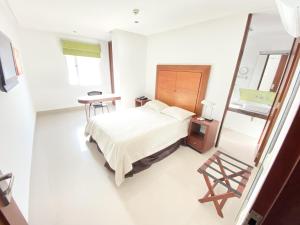 Habitación hospitalaria con cama y lavabo en Atlantic Garden Hotel, en Barranquilla