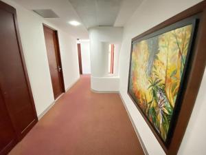 a hallway with a large painting on the wall at Atlantic Garden Hotel in Barranquilla
