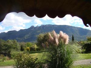 Una casa con césped y vistas a la montaña en Les Patins à Roulottes en Yenne