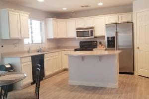 a kitchen with white cabinets and a stainless steel refrigerator at Phoenix comfort home BNB in Phoenix