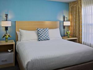 una camera da letto con un grande letto con pareti blu e due lampade di Sonesta ES Suites St. Louis - Chesterfield a Chesterfield