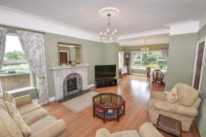 a living room with a fireplace and a tv at Ardkeen House B&B in Ardkeen