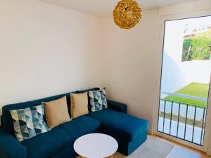 un divano blu in soggiorno con finestra di L'Azor Suites - Bleuté a Ponta Delgada