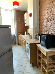 een keuken met een spoelbak en een magnetron bij Appartement de la République in La Tour-du-Pin