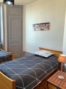 een slaapkamer met een bed en een bord aan de muur bij Appartement de la République in La Tour-du-Pin
