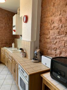 uma cozinha com um balcão com uma televisão em Appartement de la République em La Tour-du-Pin