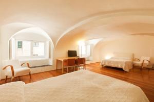 Palazzo Cicala tesisinde bir odada yatak veya yataklar