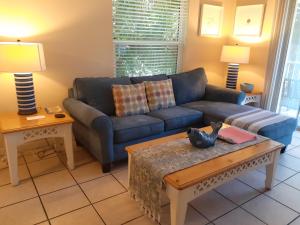 a living room with a blue couch and a table at Turtle Crawl Inn - Longboat Key in Longboat Key