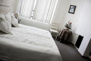 1 dormitorio con 1 cama blanca grande y 1 silla en HOTEL ROMO, en Ciudad Hidalgo