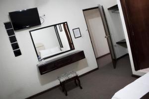 a room with a mirror and a stool and a tv at HOTEL ROMO in Ciudad Hidalgo