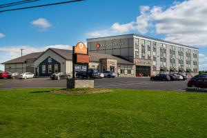FlorencevilleにあるAmsterdam Inn & Suites, Ascend Hotel Collectionの大きな建物前の駐車場