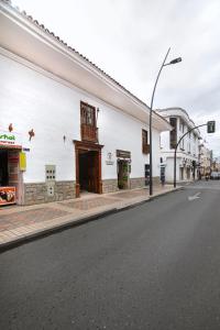 an empty street with a white building at Casa Bolívar Hotel Museo in Loja
