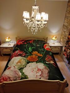 una camera da letto con un letto decorato con fiori di Gîte dix-huit a Les Hayons