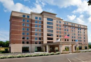 a hotel with an american flag in front of it at Sonesta Milwaukee West Wauwatosa in Wauwatosa