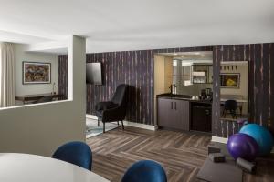 Hotel Deco في أوماها: غرفة معيشة مع طاولة وكراسي ومطبخ