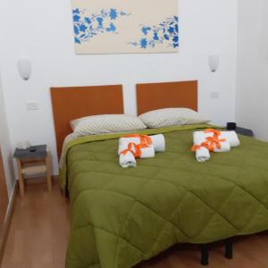 um quarto com uma cama verde e toalhas em B&B Ciccio em Taranto