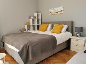 a bedroom with a large bed with yellow pillows at Deluxe Apartment "Sunset in Barbat" with sea view in Rab