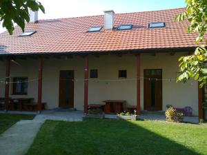 ein Haus mit einem roten Dach und einem Hof in der Unterkunft Apartman Vilo in Veľký Meder