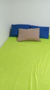 a blue and green bed with a pillow on it at Casa temporada Itanhaem in Itanhaém