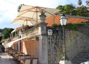 een groep stoelen en een paraplu op een muur bij Apartment Banovac 1 in Dubrovnik